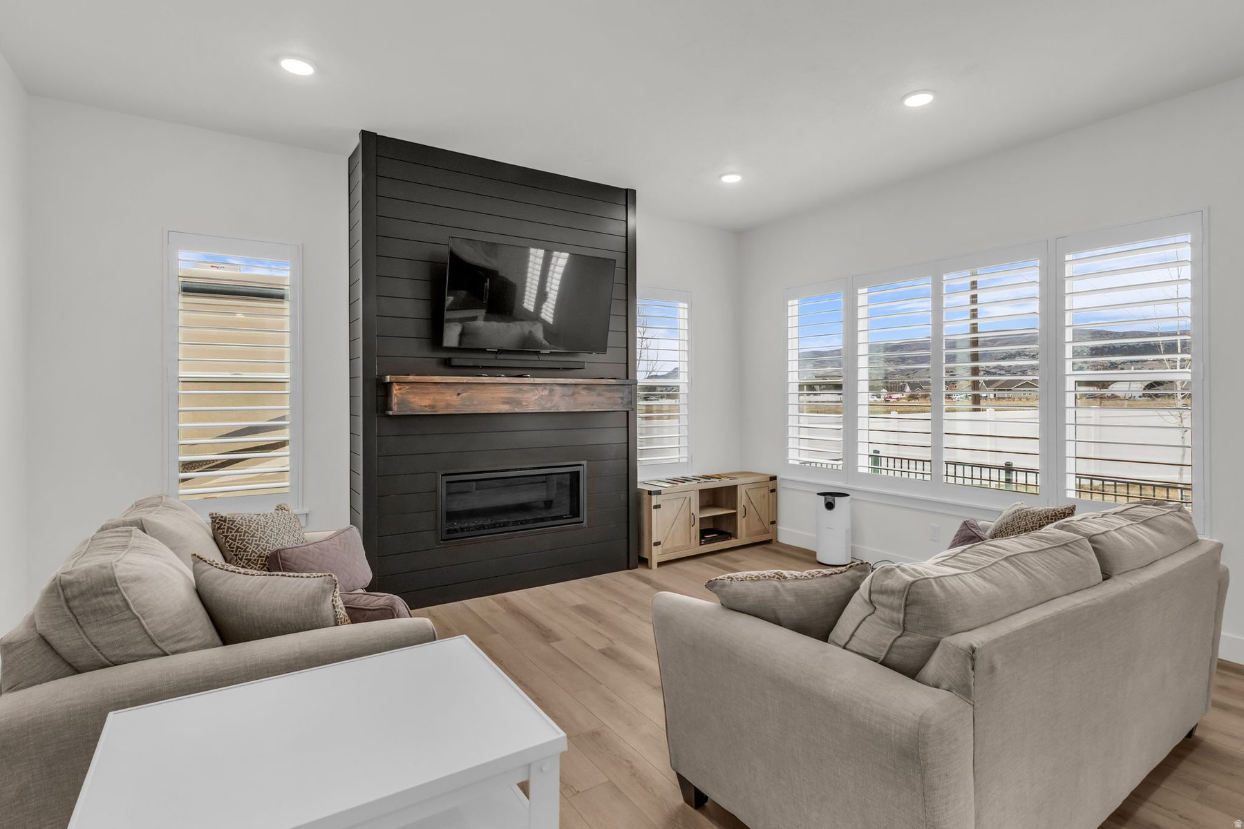 Living room at 1243 S 1040 E with black shiplap fireplace feature wall and hardwood floors
